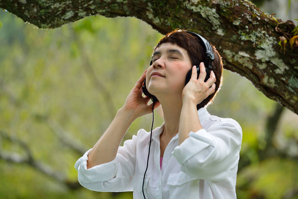 Жінка насолоджується музикою з навушниками
 - Фото, зображення