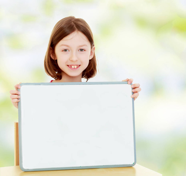 Little girl holding white poster. - Foto, Imagem