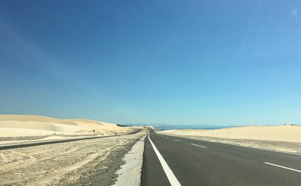 Uitzicht op de nieuwe snelweg naar de kleine nederzetting bij zonnige dag. - Foto, afbeelding