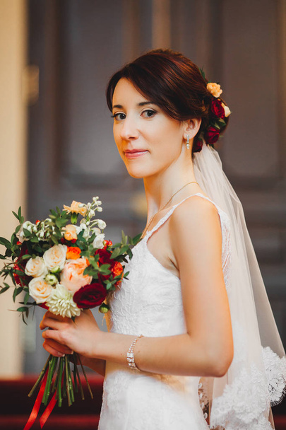 Young bride in wedding dress holding bouquet - Фото, зображення