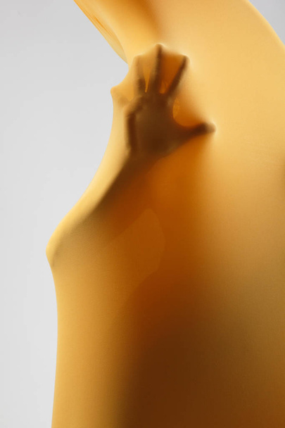female body in yellow fabric - Фото, изображение