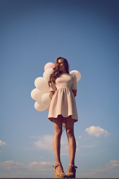 woman with balloons in blue sky - Foto, afbeelding