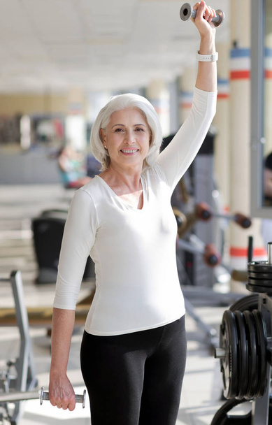Fit senior woman lifting weights. - Valokuva, kuva