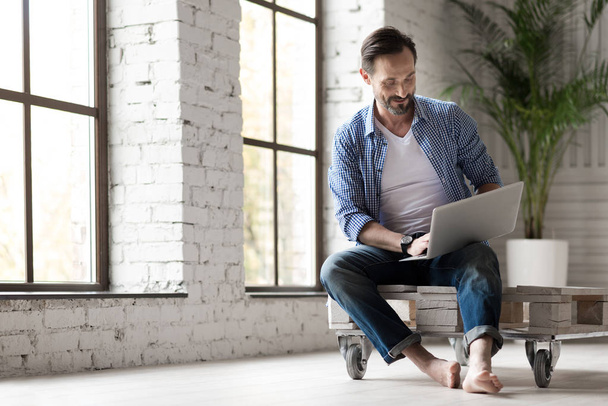 man holding a laptop on his knees - Φωτογραφία, εικόνα
