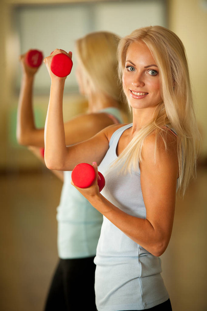 Entrenamiento de fitness - Entrenamiento de mujer en forma con dumbellc en gimnasio
 - Foto, Imagen