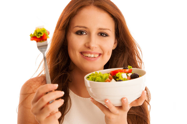 здорове харчування - жінка їсть тарілку грецького салату ізольовано над
 - Фото, зображення