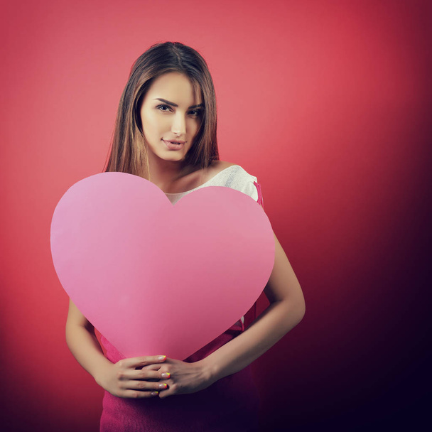 woman holding pink heart - Fotoğraf, Görsel