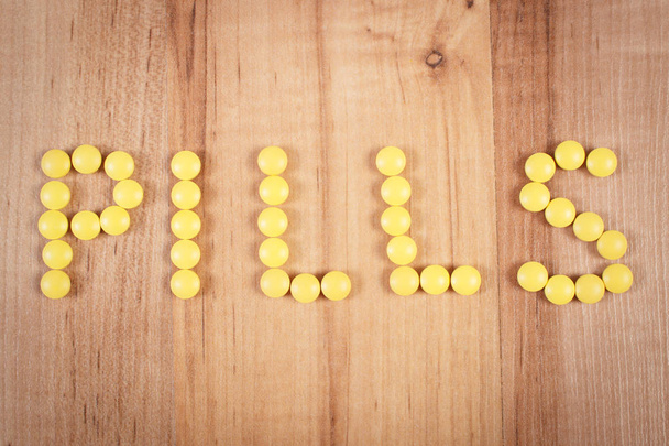 Inscription pills made of yellow medical tablets, health care concept - Foto, Imagem
