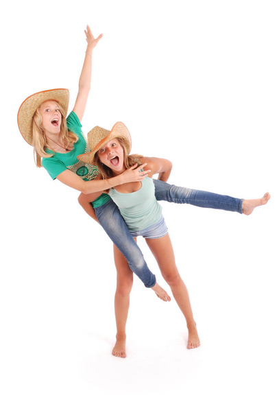 Two pretty thirteen year old girls wearing a big floppy straw su - Photo, image
