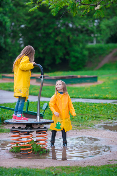 Adorables petites filles sous la pluie s'amuser en plein air
 - Photo, image