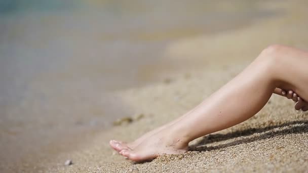 Női karcsú sima lábak a fehér homokos strand - Felvétel, videó