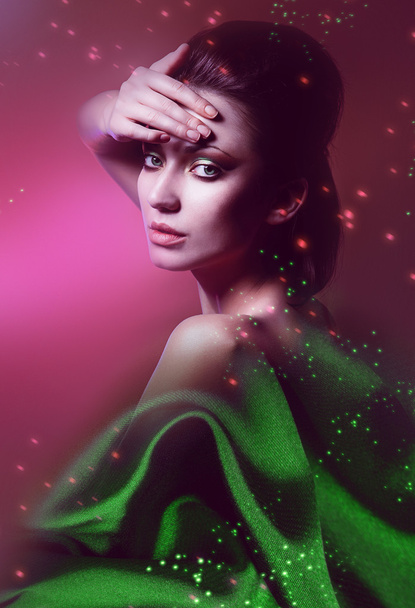 tender woman in green fabric on pink background - 写真・画像