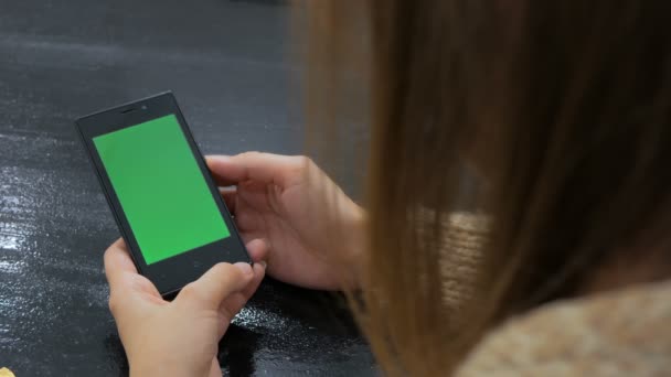 Donna che guarda smartphone con schermo verde - Filmati, video