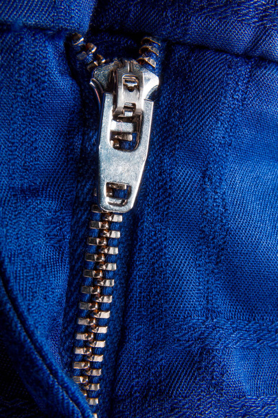 Fragment of blue jacket with metal zipper. ziplock background. Close up. - Photo, Image