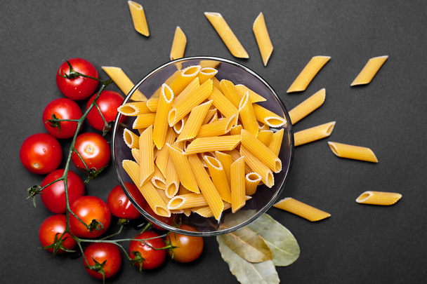 Stilleven met pasta, cherry tomaten en komkommers. De textuur van pasta. Groenten. Italiaanse Pasta. Plaats voor uw reclame. - Foto, afbeelding