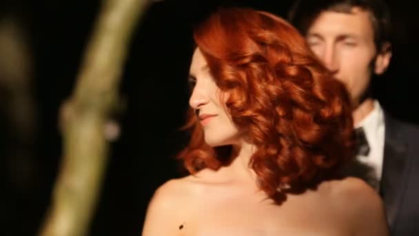 Redhead curly bride looks at groom behind her - Кадри, відео