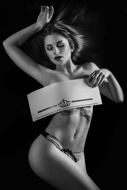 Sexy girl with a placard. Isolated on black background. - Foto, imagen