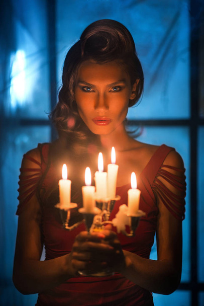 Woman looking on red candles in the fabulous night - Fotografie, Obrázek
