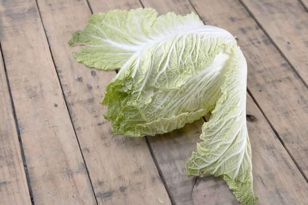 Chinese cabbage on wooden table. - Фото, изображение