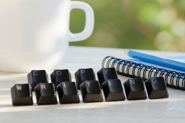 Ключи на столе, слово копирайтинг, ноутбук, карандаш, чашка, зеленый фон
 - Фото, изображение