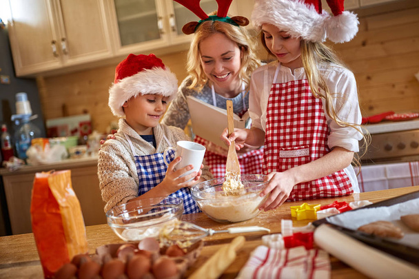 Family enjoying making Christmas cookie - Foto, afbeelding
