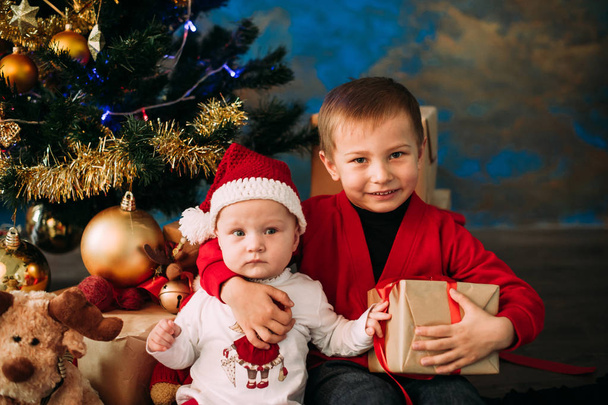 Portrait of happy children with Christmas gift boxes and decorations. Two kids having fun at home - Fotoğraf, Görsel