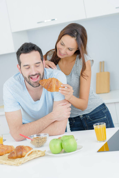 young happy couple having breakfast together with fruits and juice - Foto, imagen