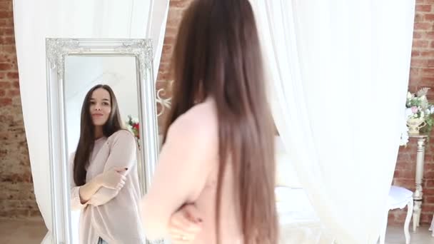 Πανέμορφο το όμορφο κορίτσι, στέκεται μπροστά από έναν καθρέφτη. - Πλάνα, βίντεο