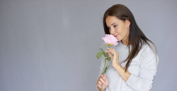 Elegáns gyönyörű nő gazdaság Rózsa virág - Fotó, kép