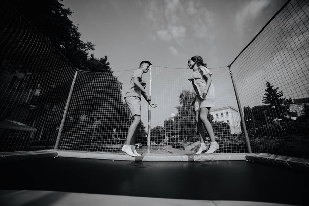 Paar springen op de trampoline in het park - Foto, afbeelding