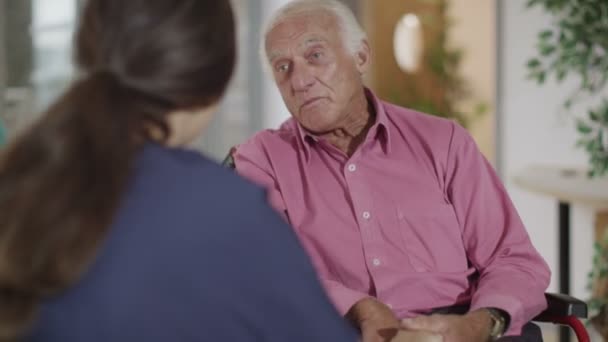 nurse giving support to elderly patient - Video, Çekim