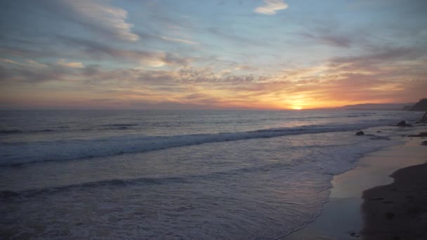 Мирне рожевий і жовтогарячий захід сонця на пляжі Mesa - Кадри, відео