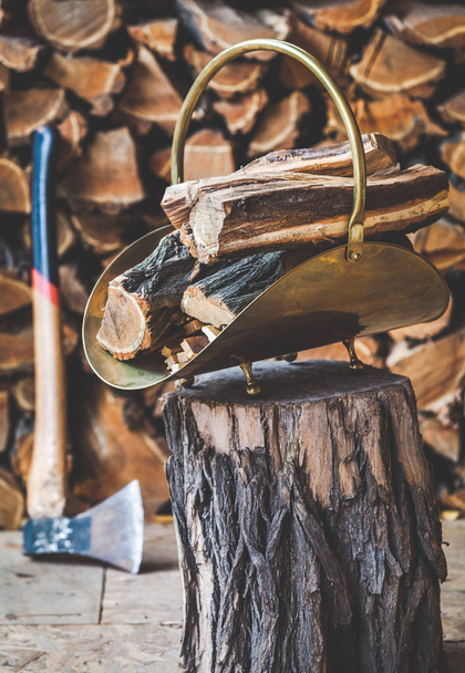 Pila de cobre de madera de pie en tronco de madera detrás del hacha
 - Foto, imagen