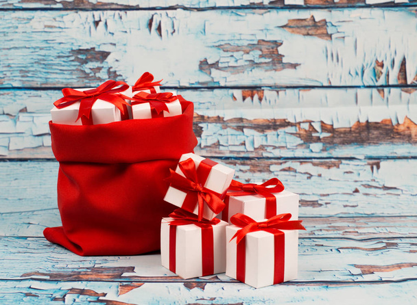 Gift box with red ribbon bow on wood background - Fotoğraf, Görsel