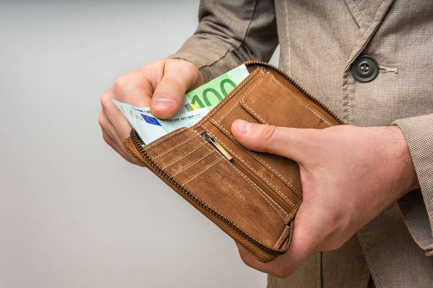 Кожаный кошелек с деньгами евро в руках мужчин
 - Фото, изображение