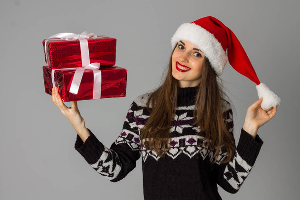 woman in warm sweater and santa hat with red gift - Foto, Bild