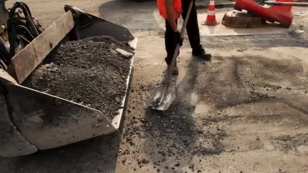 Werknemers met schoppen gooien asfalt. - Video