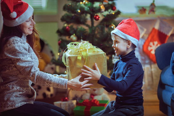 Hands of parent giving a Christmas gift to child. - Zdjęcie, obraz
