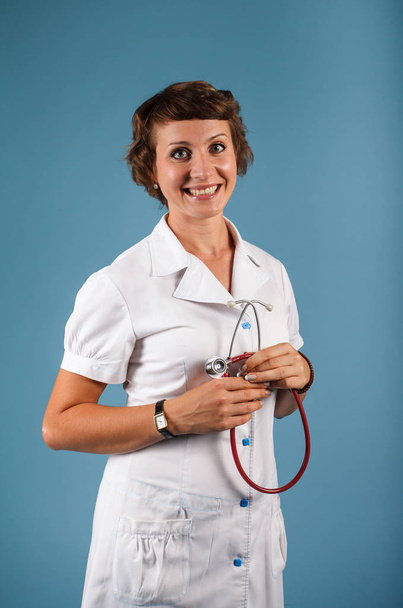 Portrait of a young woman doctor with stethoscope in studio - Photo, Image