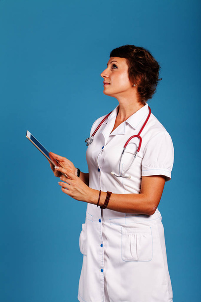 nuori nainen lääkäri, jolla tabletti käsissä, lääke
 - Valokuva, kuva