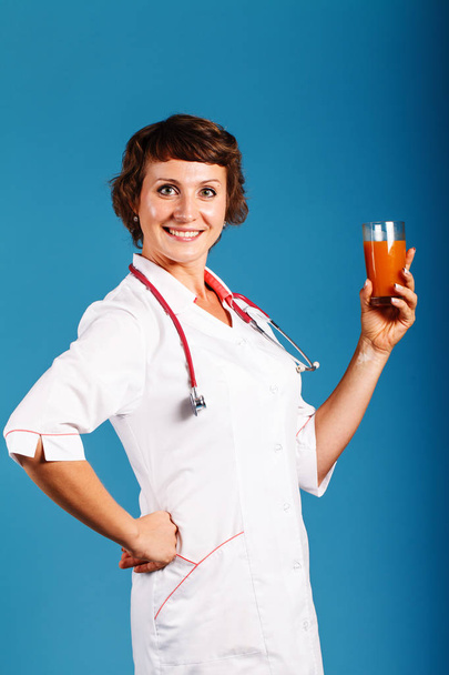 フレッシュ ジュースのグラスを持つ若い女性医師 - 写真・画像