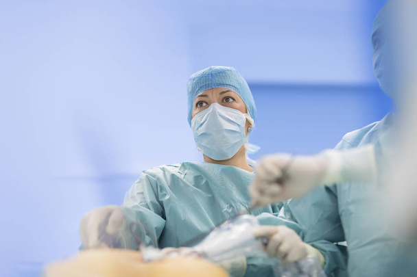 Surgeons performing surgery in operating Theater. - Фото, изображение