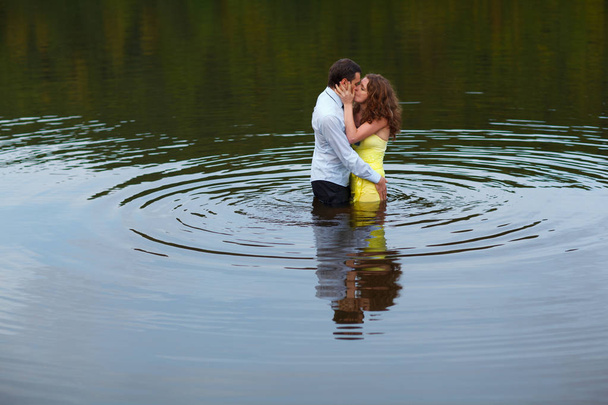 Man kisses a woman standing in water  - Foto, afbeelding