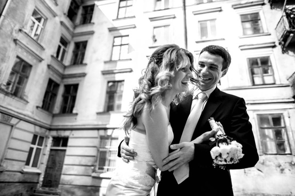 Bride laugh while groom hugs her  - Valokuva, kuva