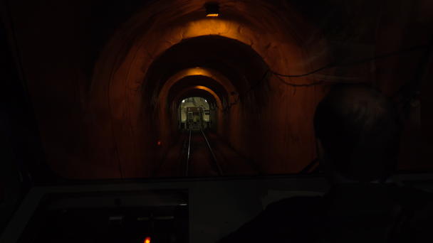 Sterownik działa kolejką linową przez ciemny tunel - Materiał filmowy, wideo