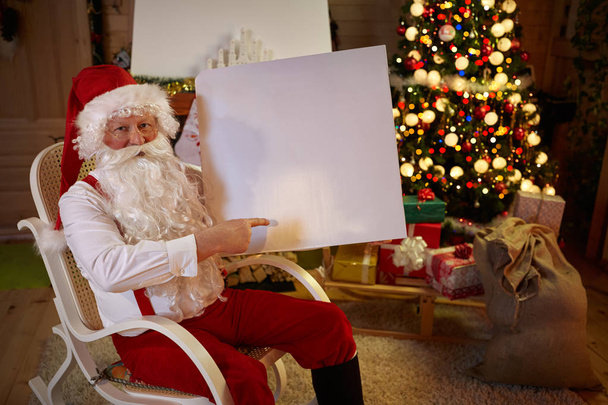Santa Claus pointing at white banner - Фото, изображение