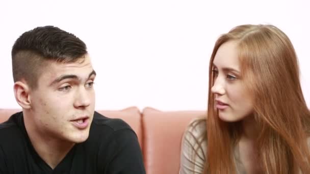 beautiful young couple conflict sitting on a couch argue unhappy - Video