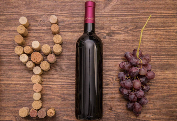 Lahve na víno, sklenice vína, vinných hroznů a vína korek na dřevěné pozadí. - Fotografie, Obrázek