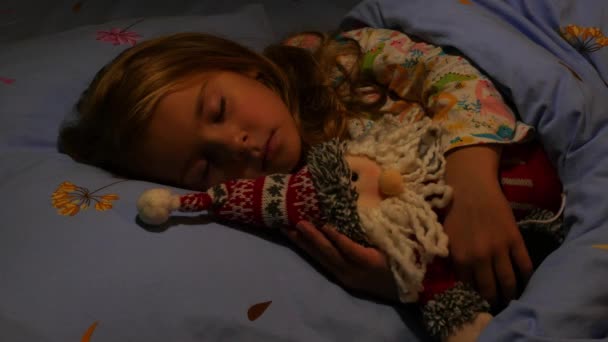 Mädchen schläft mit Weihnachtsmann-Spielzeug. Nahaufnahme. - Filmmaterial, Video