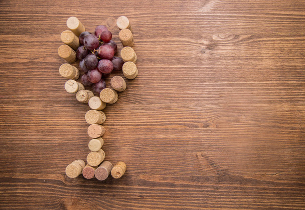 Verre fait avec du vin de liège et des raisins à l'intérieur sur fond de bois
 - Photo, image